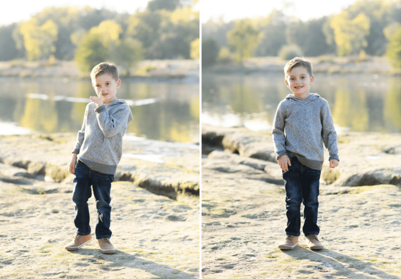 young boy picking nose, smiling in front of the river