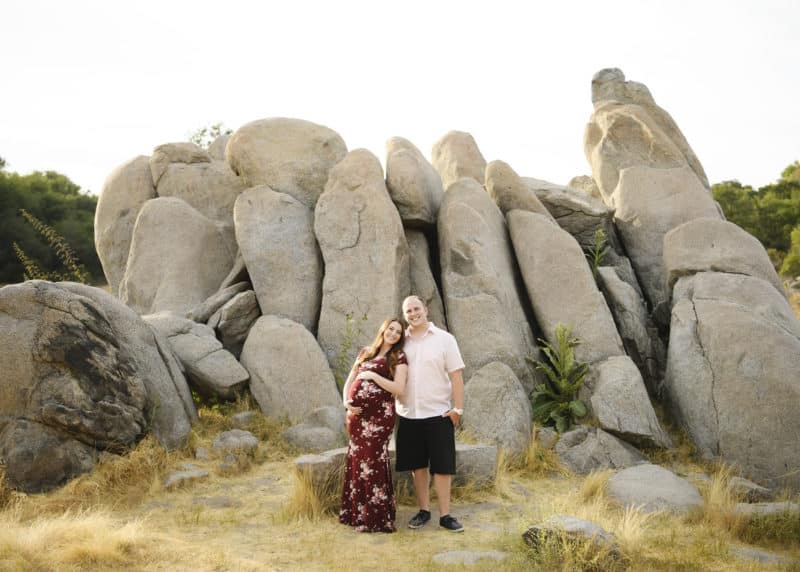 couple posing in front of rock formation maternity photo session granite bay california