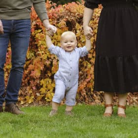 young boy holding parents’ hands fall family photos
