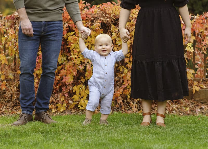 young boy holding parents' hands fall family photos