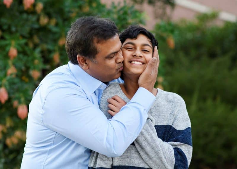 dad kissing son on the cheek
