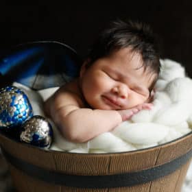 newborn baby boy smiling in a basket