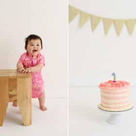 one year old baby girl smiling, smash cake with one candle