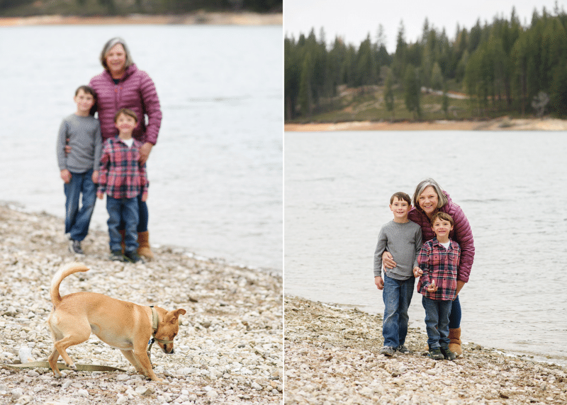family of three posing by the lake on camping trip