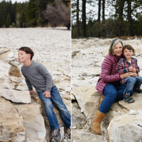 mom and two young sons stacking rocks by the lake
