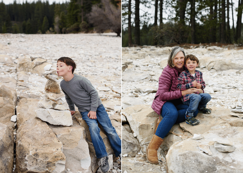 mom and two young sons stacking rocks by the lake