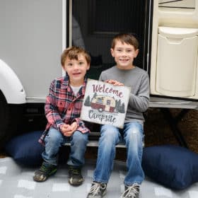 two brothers posing in front of family camper