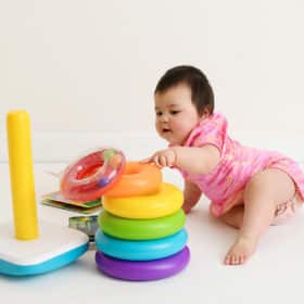 one year old baby girl playing with toy studio photo shoot