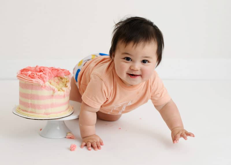 one year old baby girl crawling with smash cake
