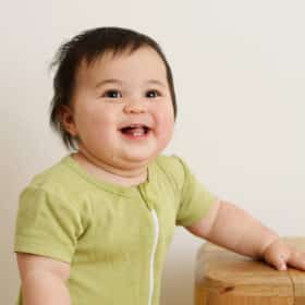 one year old baby girl smiling at the camera studio photo shoot