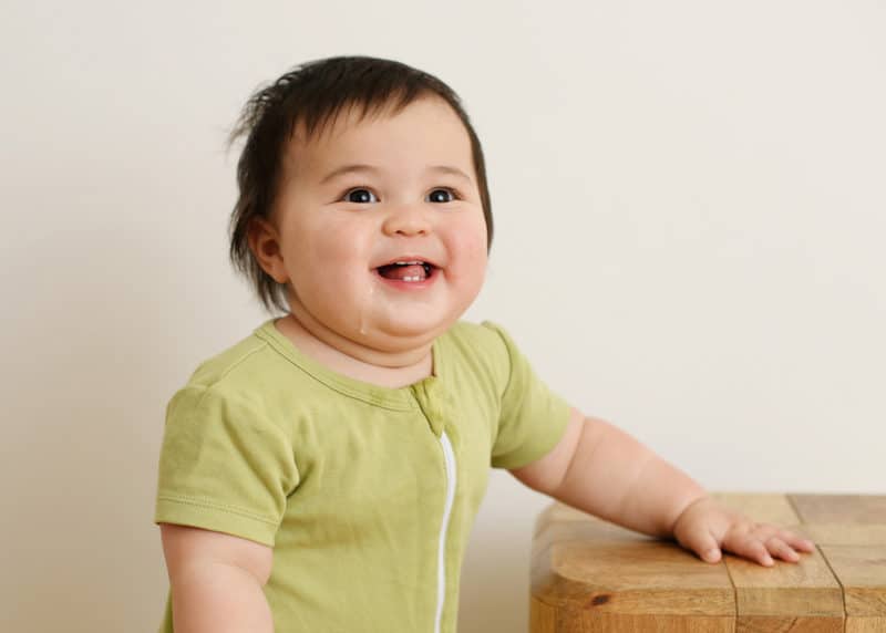 one year old baby girl smiling at the camera studio photo shoot