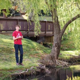 teen boy fishing by the river senior photo session