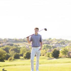senior high school boy posing with golf club on the course