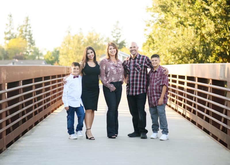 family of five posing outdoors on a bridge in elk grove california