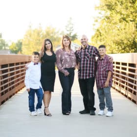 family of five posing together on bridge outdoors in elk grove california
