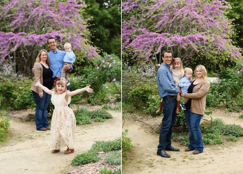 mom and dad with two young kids posing together in spring