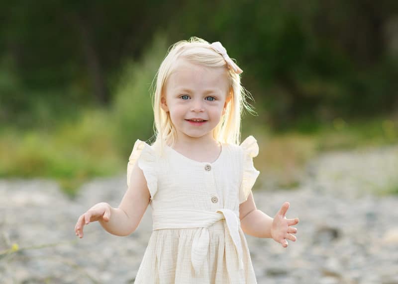toddler girl posing by the river in yellow dress fair oaks california
