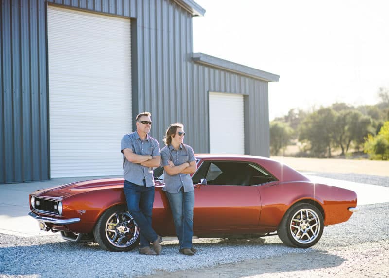 dad and son posing in front of classic chevy camero and garage rescue california