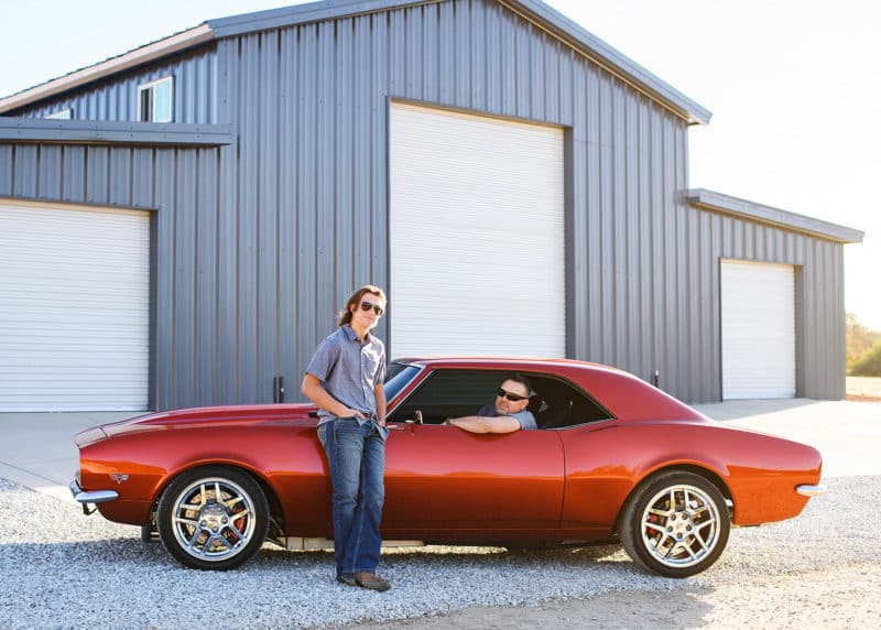 dad driving old chevy camero, son looking on during photo session 