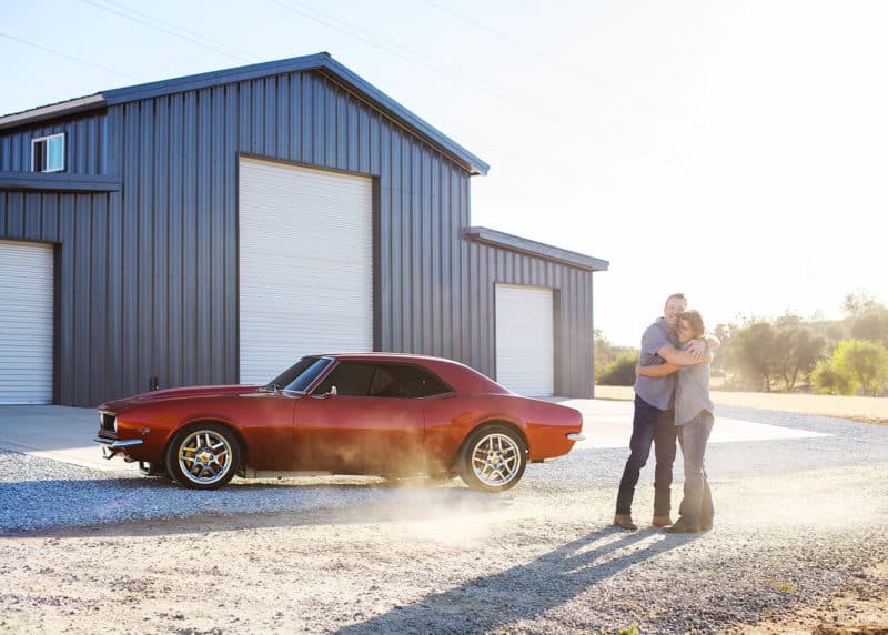 dad and son hugging beside classic chevy camero and garage rescue california