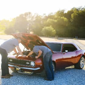 dad and son working on classic car engine during golden hour rescue california