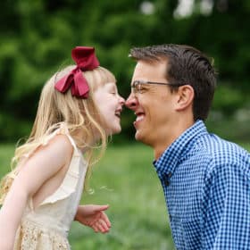young girl with dad giving nose kisses in the grass sacramento california