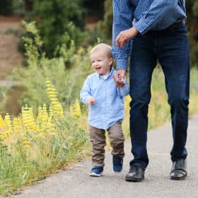 dad holding son’s hand along a path with wildflowers in sacramento california