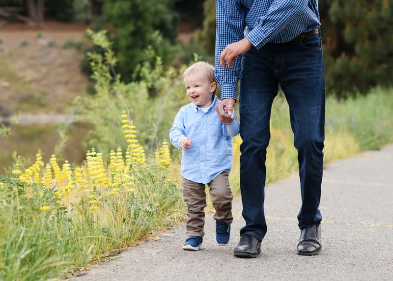 dad holding son's hand along a path with wildflowers in sacramento california