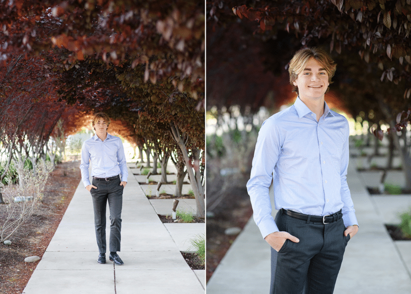 high school senior boy posing along tree-lined path for senior photos sacramento california