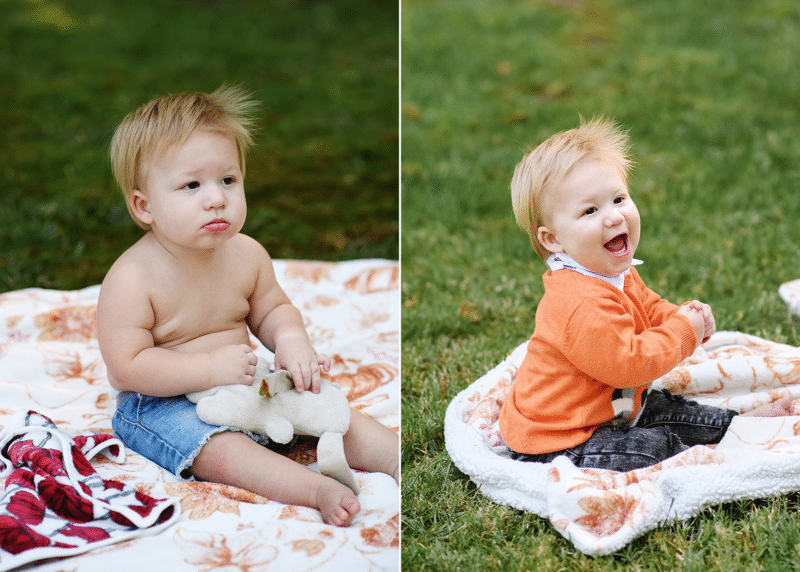 baby boy sitting on a blanket outside in the grass pouting and laughing