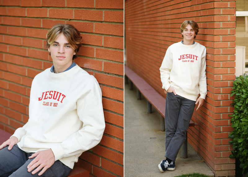 jesuit high school senior boy posing along brick wall senior portraits