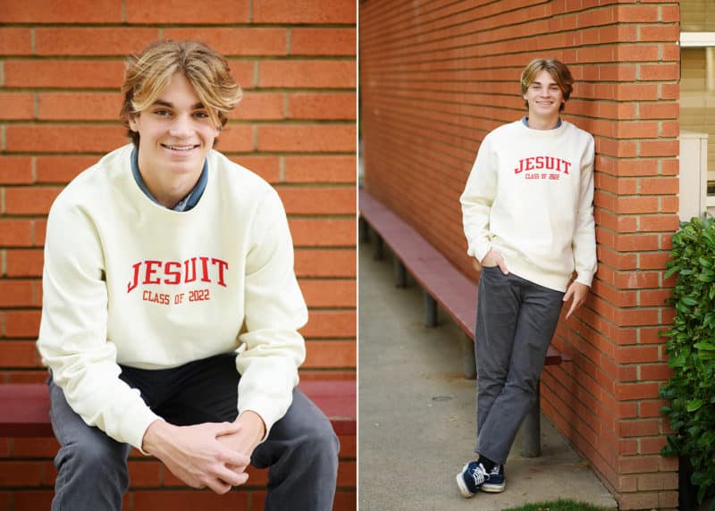 jesuit high school senior boy posing along brick wall senior portraits