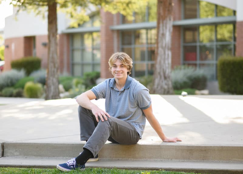 high school senior boy casually posing outside on school steps sacramento california