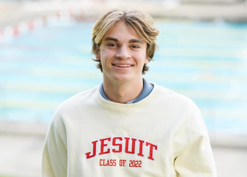 high school senior boy in front of swimming pool, red brick wall sacramento california