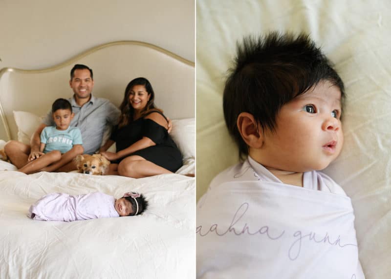 family of four sitting on bed with newborn baby girl wrapped in name blanket
