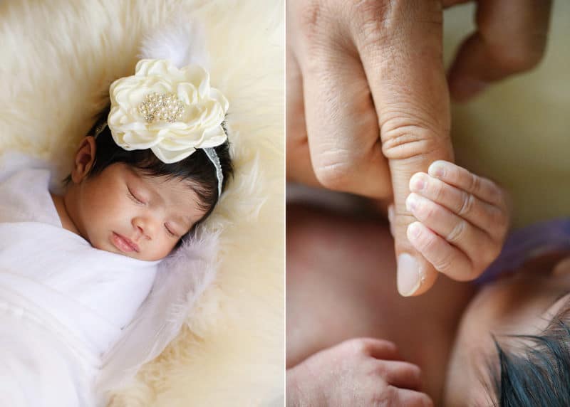 newborn baby girl with flower headband, holding mom's finger in home photo session