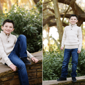 young boy on a stone wall outdoors with trees in natural light