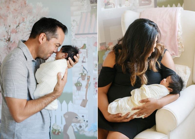 dad kissing newborn daughter in home nursery, mom holding baby in a rocking chair