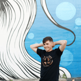 teenage boy in front of blue and white mural in downtown sacramento