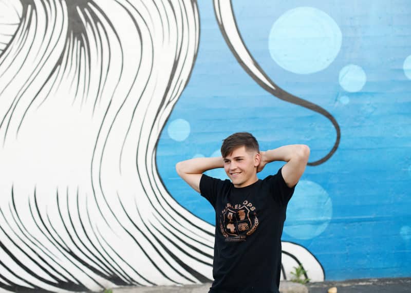 teenage boy in front of blue and white mural in downtown sacramento