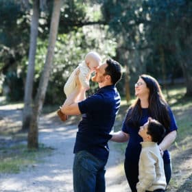 dad kissing baby, mom and son looking on natural light family photo