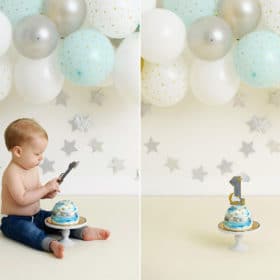 one year birthday cake in front of balloon garland, boy holding one year cake topperastle4