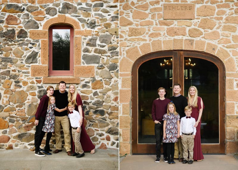 mom and dad with three kids standing in front of old family stone wine storage in napa california