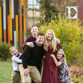 taking family photos by the vineyard barn and laughing together