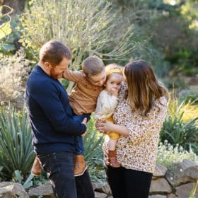 family of four hugging together and laughing in succulent garden in sacramento california