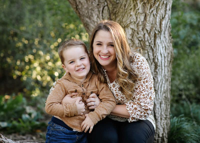 mom with young son sitting and laughing for fall family photos in sacramento california
