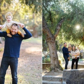 dad holding young daughter on his shoulders, family of four posing by a tree during fall family photos