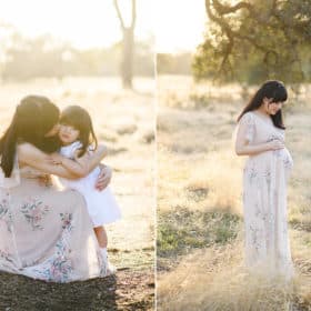 mom hugging young daughter during maternity photos, holding belly in the sunset