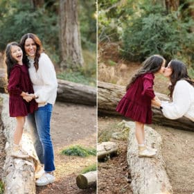 Mom with young daughter walking along a log in the forest in davis california