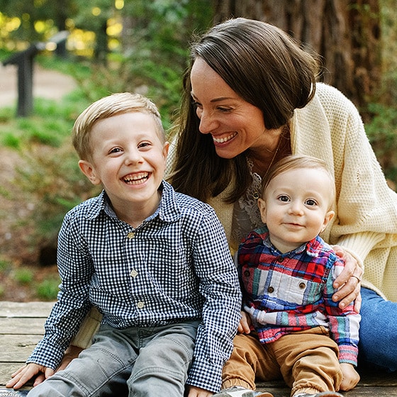 mom with two young boys laughing together during fall family photos